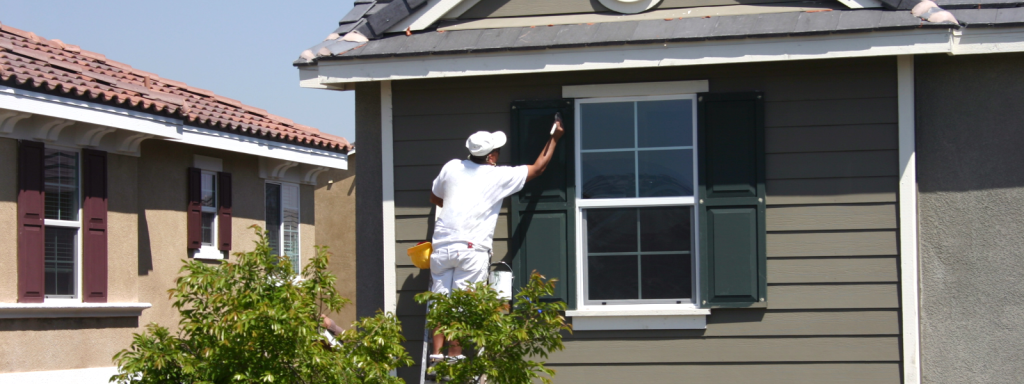 House painter working on exterior of house to get a house ready for sale