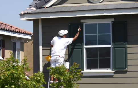 House painter working on exterior of house to get a house ready for sale